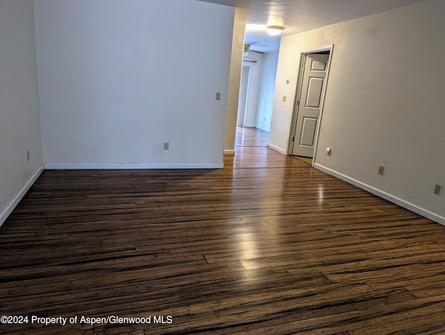 empty room with dark hardwood / wood-style flooring