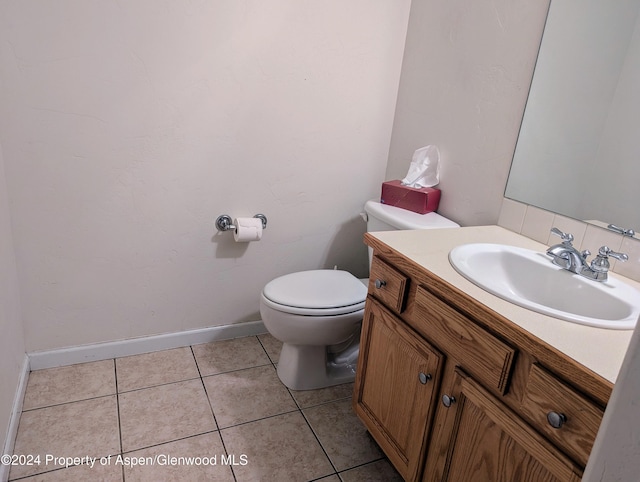 bathroom with tile patterned flooring, vanity, and toilet