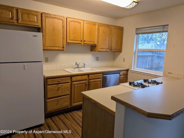 kitchen featuring dark wood-type flooring, white refrigerator, sink, stainless steel dishwasher, and kitchen peninsula