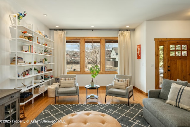 living area featuring baseboards, wood finished floors, and recessed lighting