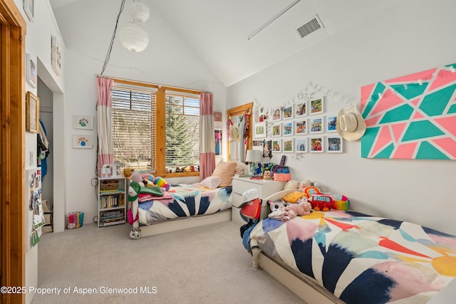 carpeted bedroom with high vaulted ceiling and visible vents