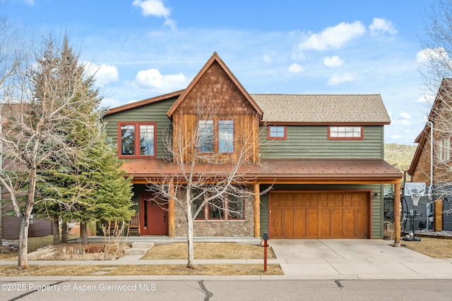 view of front of property featuring a shingled roof, concrete driveway, stone siding, and an attached garage