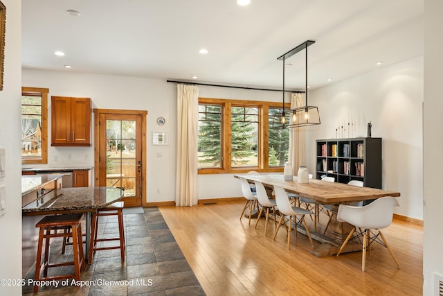 dining space featuring a chandelier, recessed lighting, baseboards, and wood finished floors