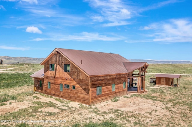 view of side of home with metal roof and a mountain view