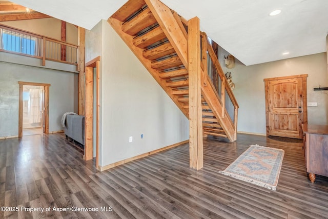 unfurnished living room with dark wood-style floors, stairway, recessed lighting, and baseboards