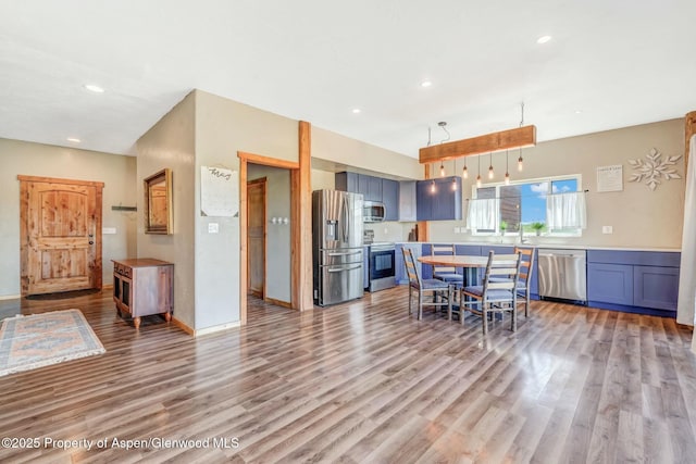 kitchen featuring blue cabinetry, light wood-style floors, appliances with stainless steel finishes, and light countertops