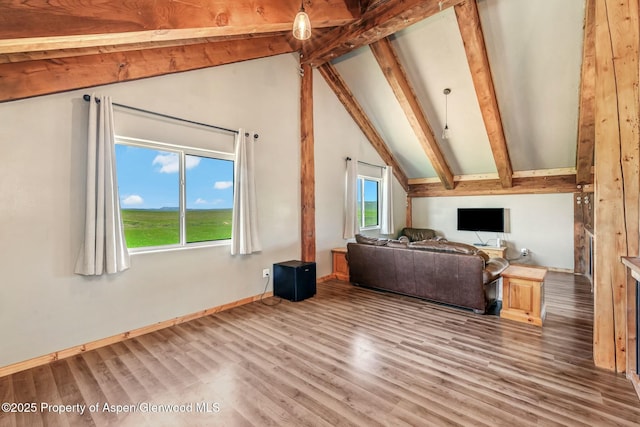 additional living space with a healthy amount of sunlight, vaulted ceiling with beams, baseboards, and light wood finished floors