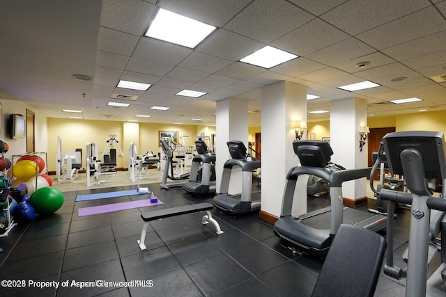 gym with a paneled ceiling, baseboards, and visible vents