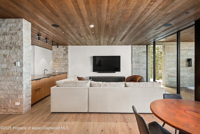 living room featuring recessed lighting, wooden ceiling, a wall of windows, and light wood-type flooring