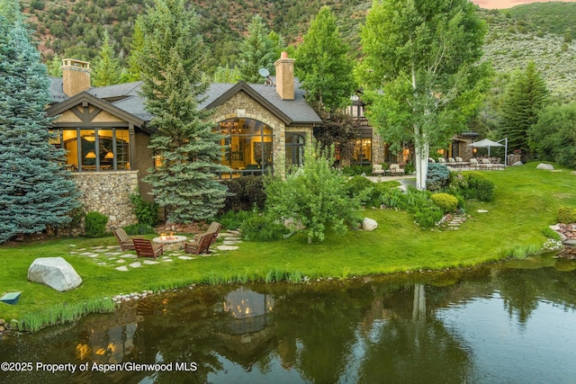 120 Running Mare Rd, Woody Creek, CO 81656 - rear view of house with stone siding, a gazebo, a chimney, a lawn, and an outdoor fire pit