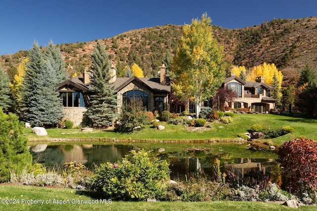 120 Running Mare Rd, Woody Creek, CO 81656 - back of house with a water and mountain view, a chimney, a yard, a wooded view, and stone siding