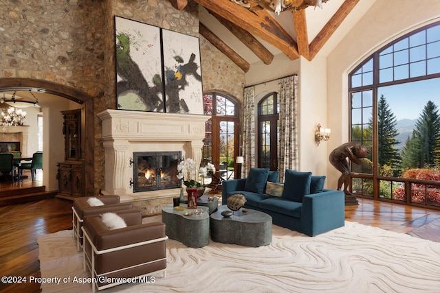 120 Running Mare Rd, Woody Creek, CO 81656 - living area featuring a glass covered fireplace, high vaulted ceiling, wood-type flooring, beam ceiling, and arched walkways