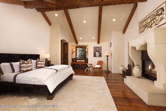 120 Running Mare Rd, Woody Creek, CO 81656 - bedroom featuring arched walkways, recessed lighting, a glass covered fireplace, and wood finished floors