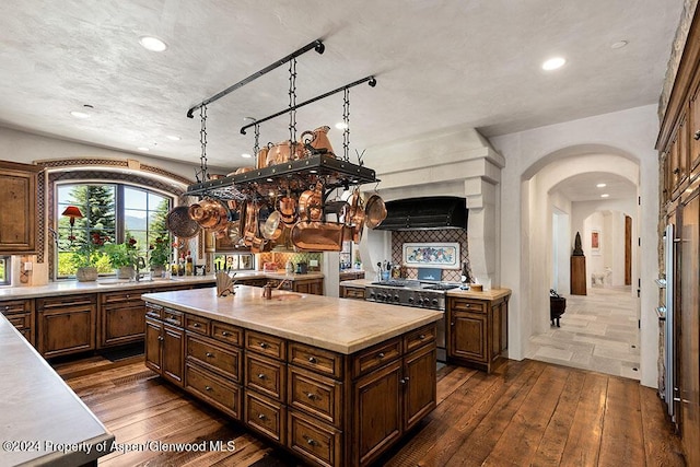 120 Running Mare Rd, Woody Creek, CO 81656 - kitchen featuring double oven range, dark wood-style flooring, arched walkways, light countertops, and range hood