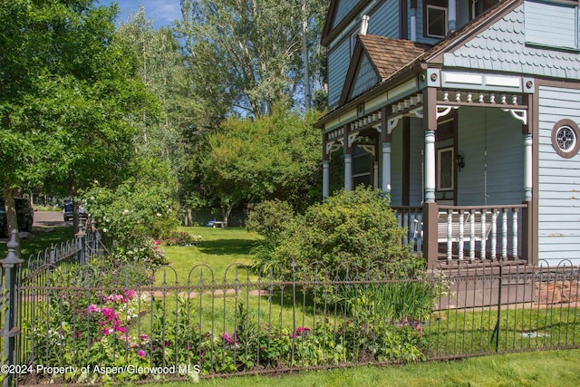 500 W Francis St, Aspen, CO 81611 - view of side of property featuring fence, a lawn, and covered porch