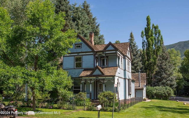500 W Francis St, Aspen, CO 81611 - victorian home with a chimney, a front lawn, covered porch, fence, and a garage