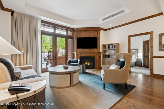 415 E Dean St Unit 31, Aspen, CO 81611 - living room featuring a fireplace, hardwood / wood-style flooring, a tray ceiling, and crown molding