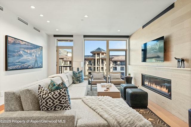 living room featuring wood-type flooring and a fireplace