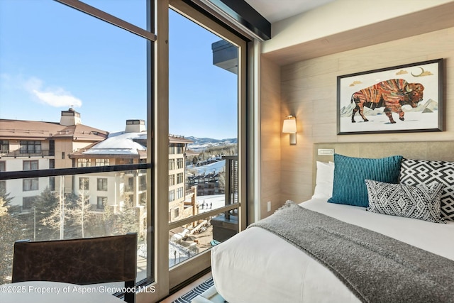 bedroom with multiple windows and wood walls