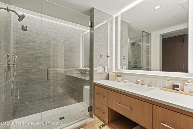 bathroom featuring tile patterned floors, walk in shower, and vanity