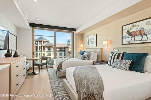 bedroom with access to exterior and light hardwood / wood-style floors