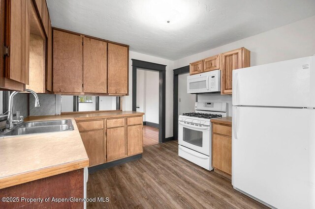 580 Curtis Ave, De Beque, CO 81630 - kitchen with white appliances, a sink, dark wood-style floors, and light countertops