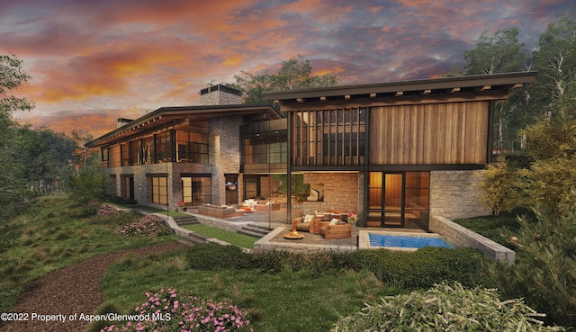 back house at dusk featuring outdoor lounge area and a patio