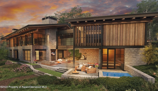 back house at dusk featuring an outdoor hangout area and a patio area