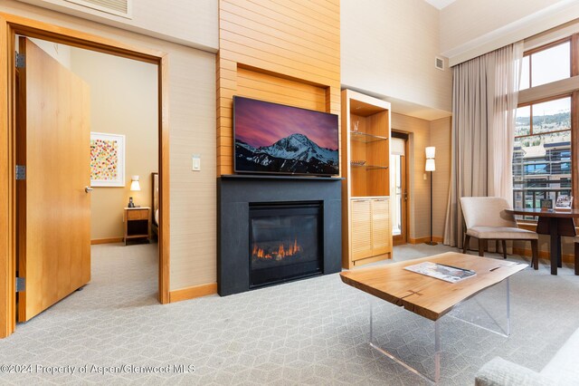 living room featuring light colored carpet and a high ceiling