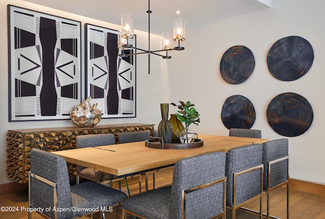 dining space featuring hardwood / wood-style floors and a notable chandelier