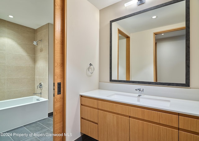 bathroom featuring tile patterned flooring, tiled shower / bath combo, and vanity