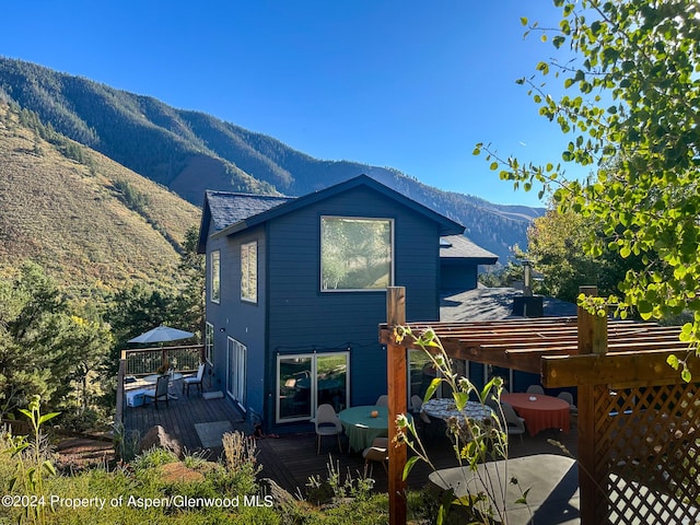 rear view of house with a deck with mountain view