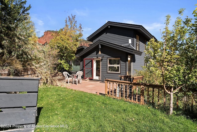 rear view of property featuring a yard and a patio