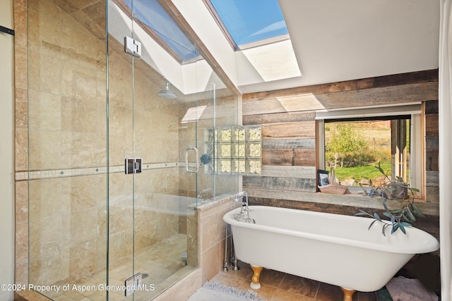 bathroom with tile patterned floors, a skylight, and separate shower and tub