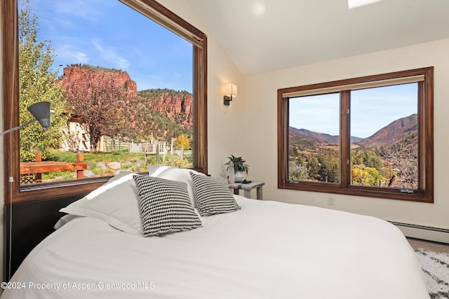 bedroom featuring a mountain view, lofted ceiling, and a baseboard heating unit