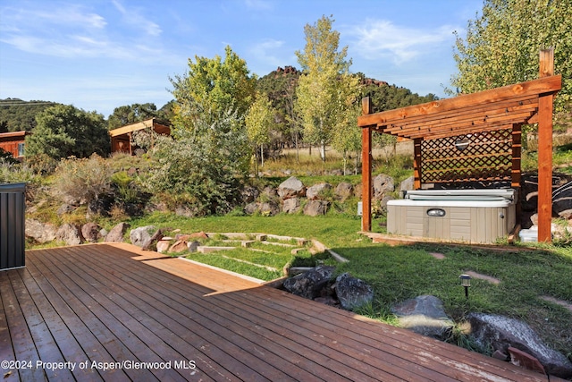 deck with a lawn, a pergola, and a hot tub