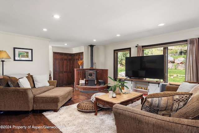 living room featuring dark hardwood / wood-style flooring, a wood stove, and ornamental molding