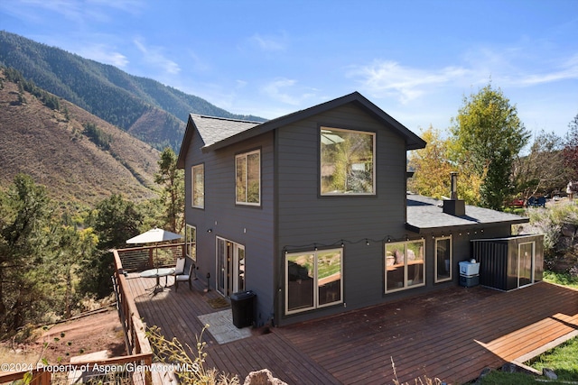 rear view of property featuring a deck with mountain view