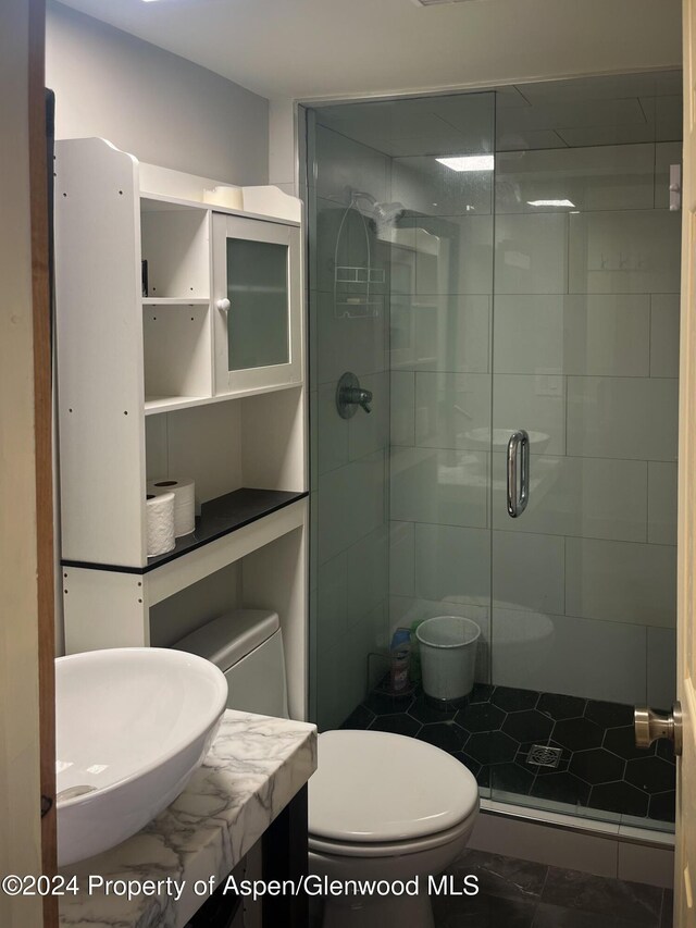 bathroom with tile patterned floors, sink, toilet, and walk in shower