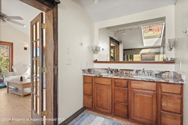 bathroom featuring ceiling fan, lofted ceiling, and vanity