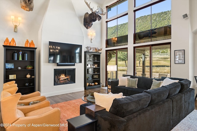 living room with a high ceiling, a large fireplace, and dark hardwood / wood-style floors