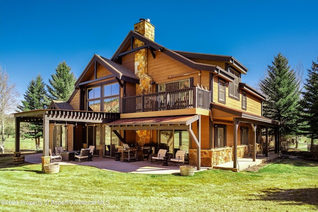 rear view of property featuring a patio and a lawn