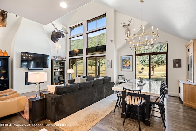 living room featuring dark hardwood / wood-style floors, high vaulted ceiling, and a notable chandelier