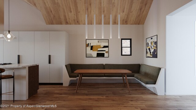 dining room featuring breakfast area, dark wood-type flooring, vaulted ceiling, and wooden ceiling