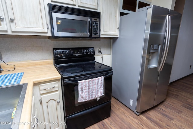 kitchen with dark hardwood / wood-style flooring, stainless steel appliances, and tasteful backsplash