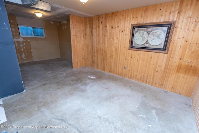 basement featuring wood walls