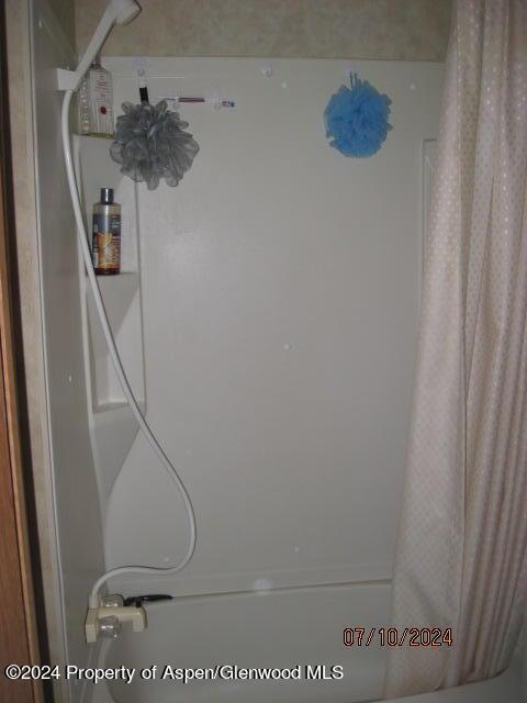 details featuring shower / bath combination with curtain