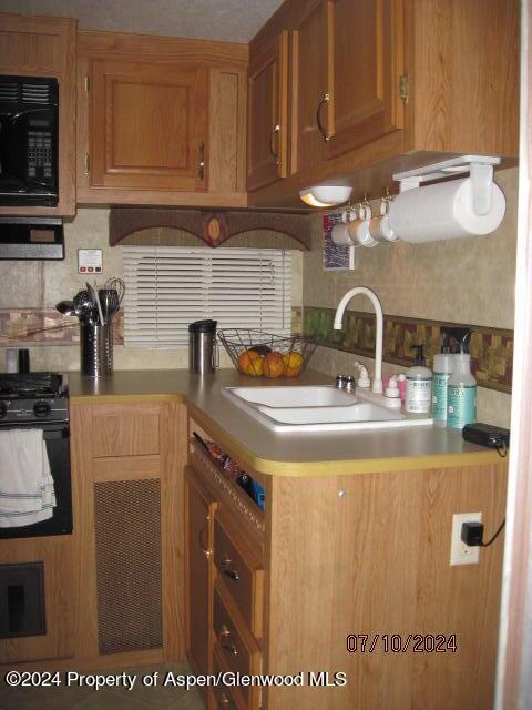 kitchen with stove, sink, and tasteful backsplash