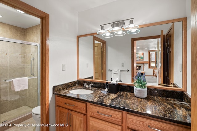 bathroom featuring walk in shower, tile patterned flooring, vanity, and toilet