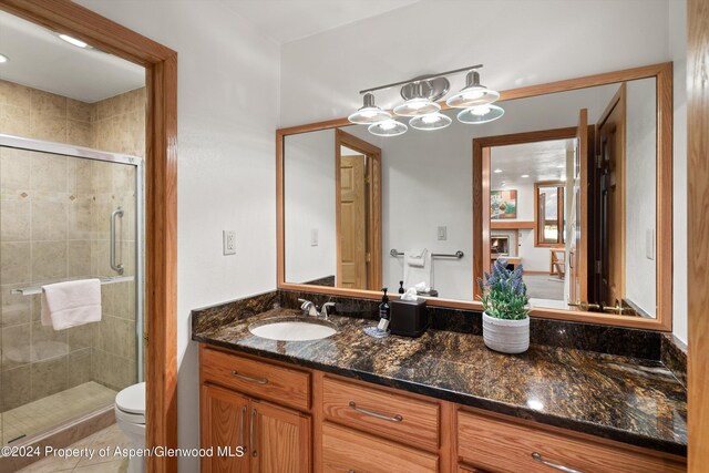 bathroom featuring walk in shower, tile patterned flooring, vanity, and toilet